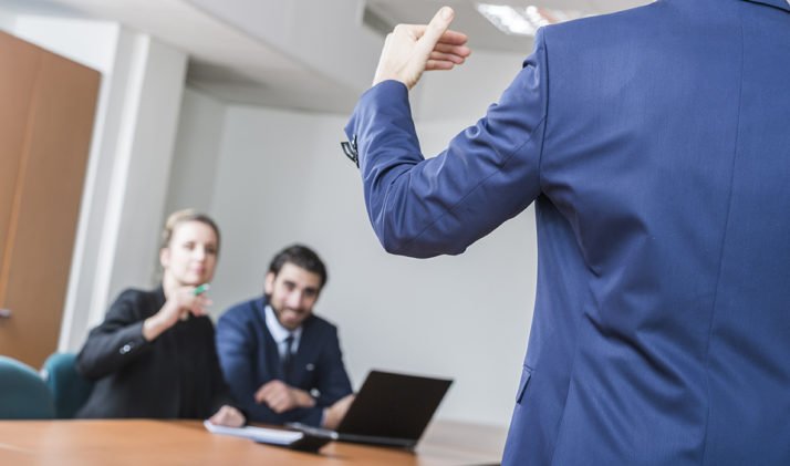 homme debout réunion duo assis ordinateur