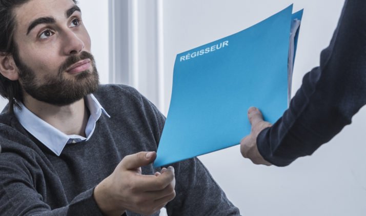homme barbe dossier bleu panneau régisseurs